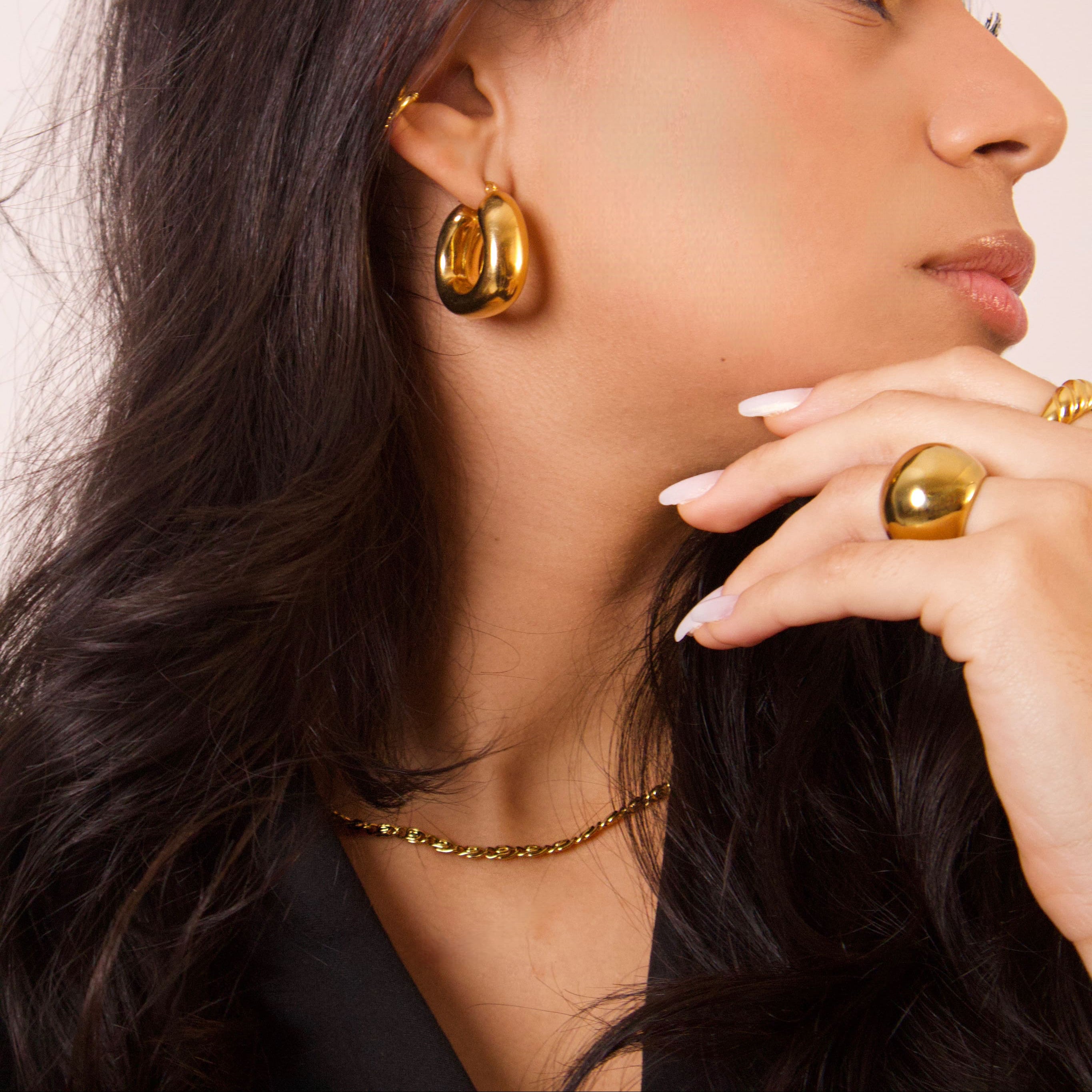 Close-up detail of sculptural gold chain necklace links
