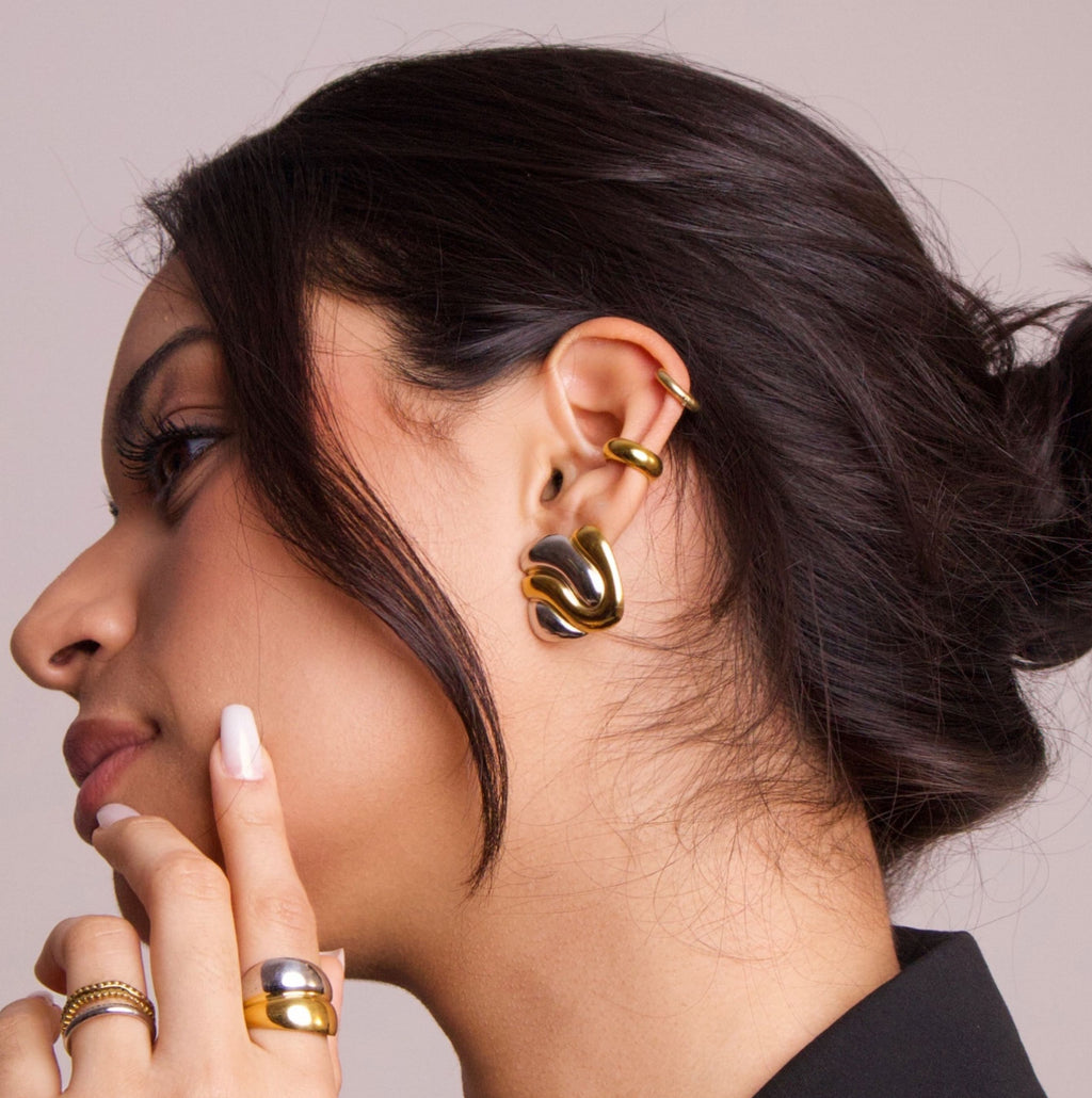 Gold ear cuff worn on ear with sculptural design, showing fit and placement
