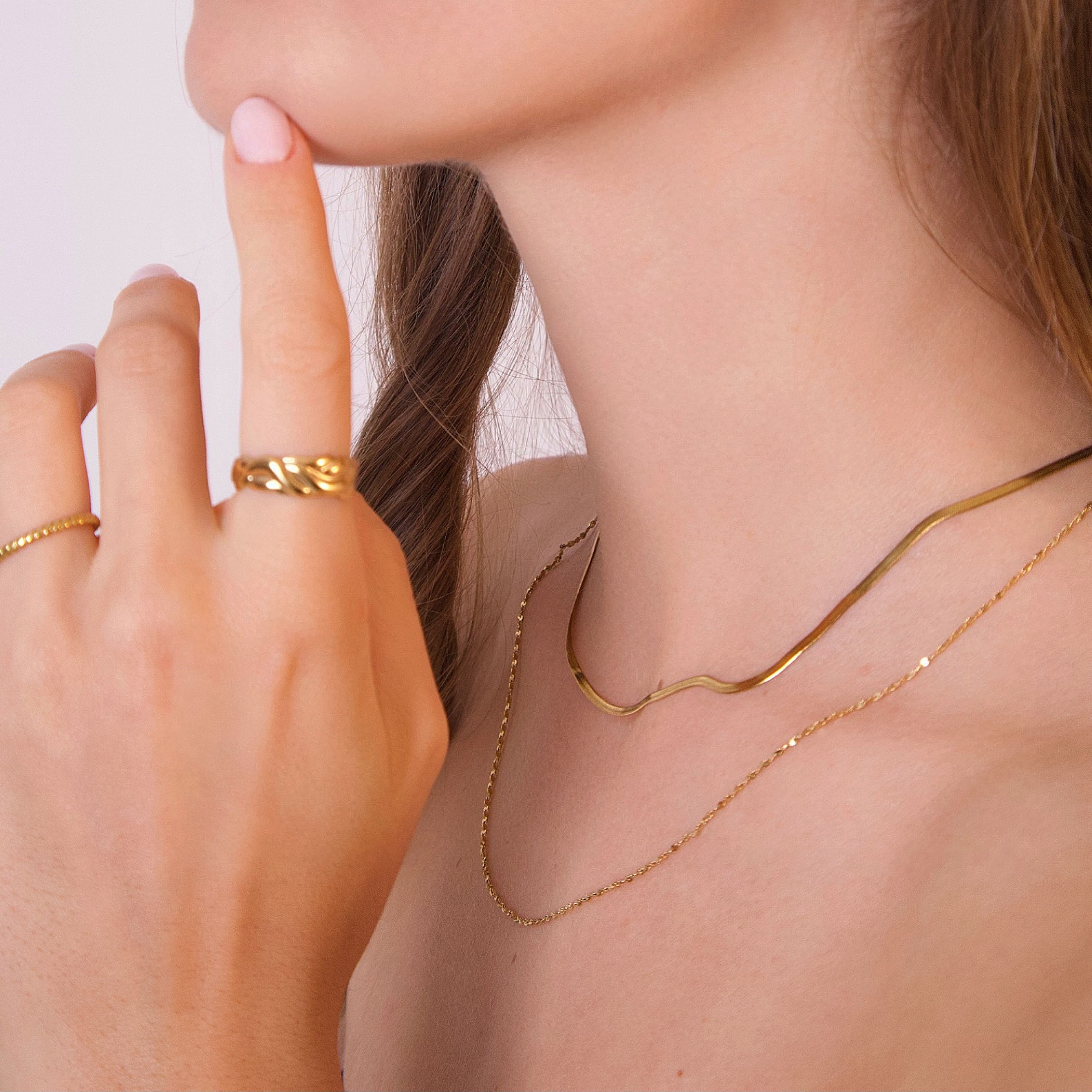 Gold faceted chain necklace with delicate polished links displayed on white background
