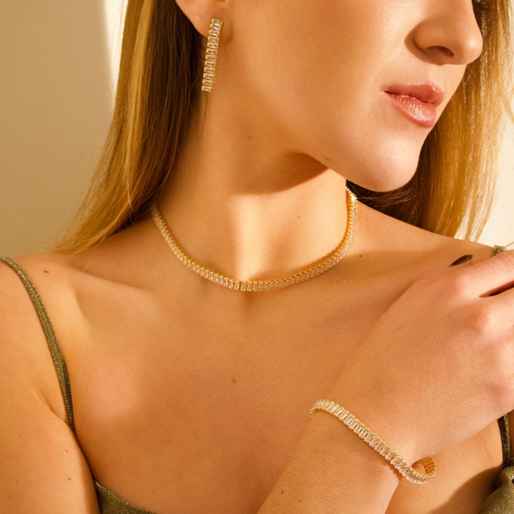 Gold crystal jewelry set featuring a necklace, matching earrings and bracelet
