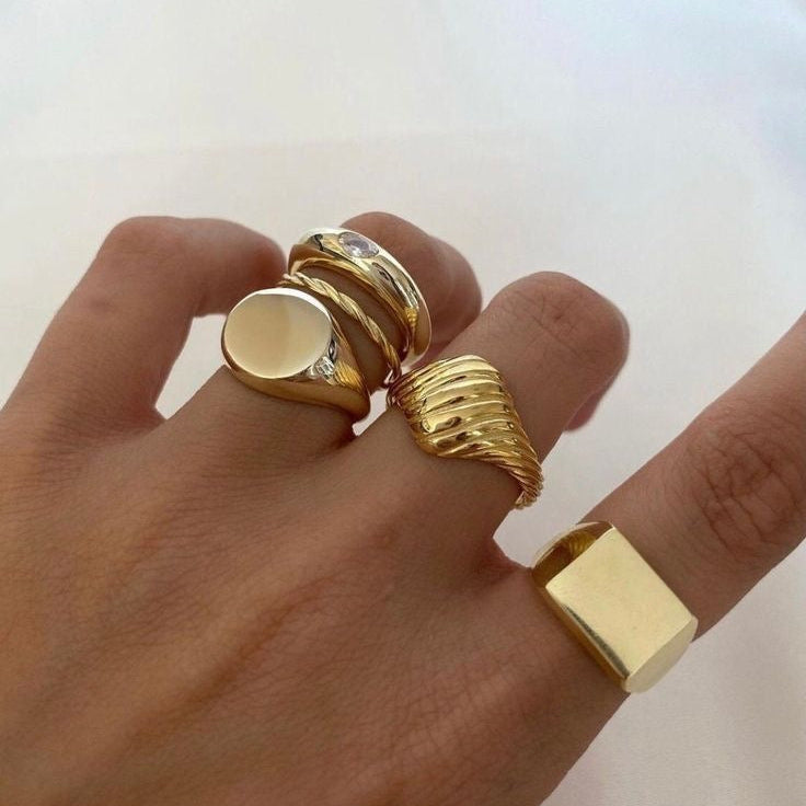 Minimal gold signet ring with smooth polished finish on white background
