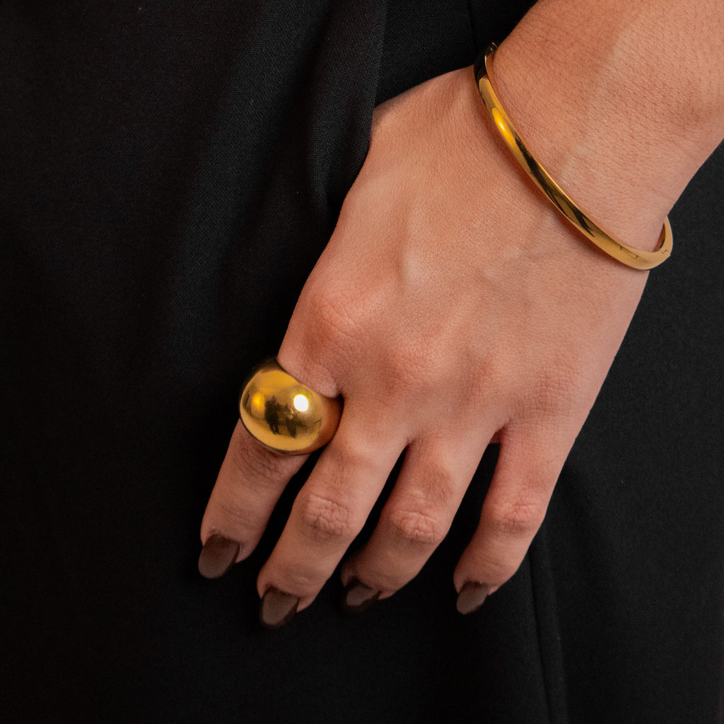 Polished gold bangle with a minimalist smooth finish