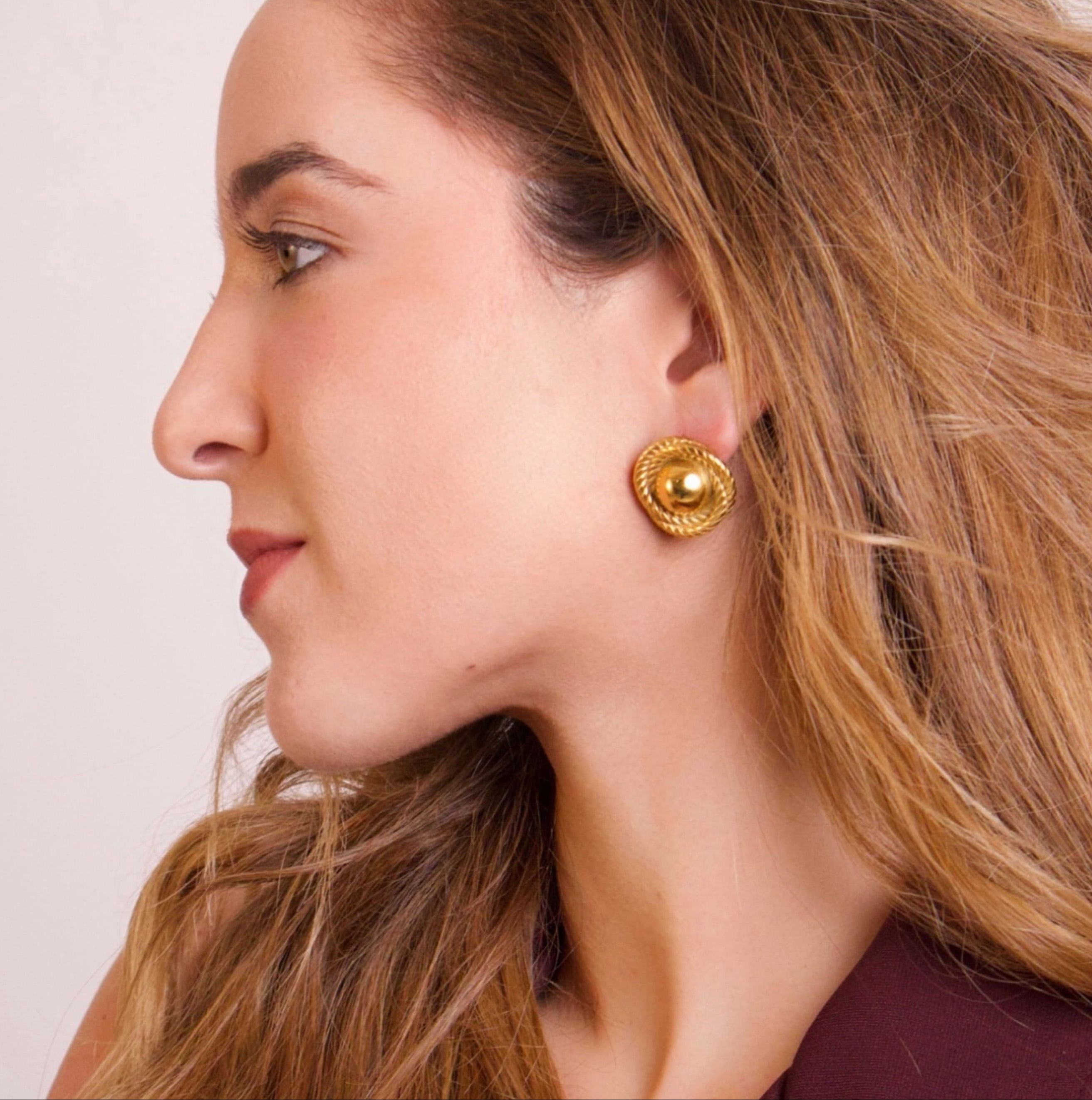 Textured gold stud earrings with a timeless design worn by model
