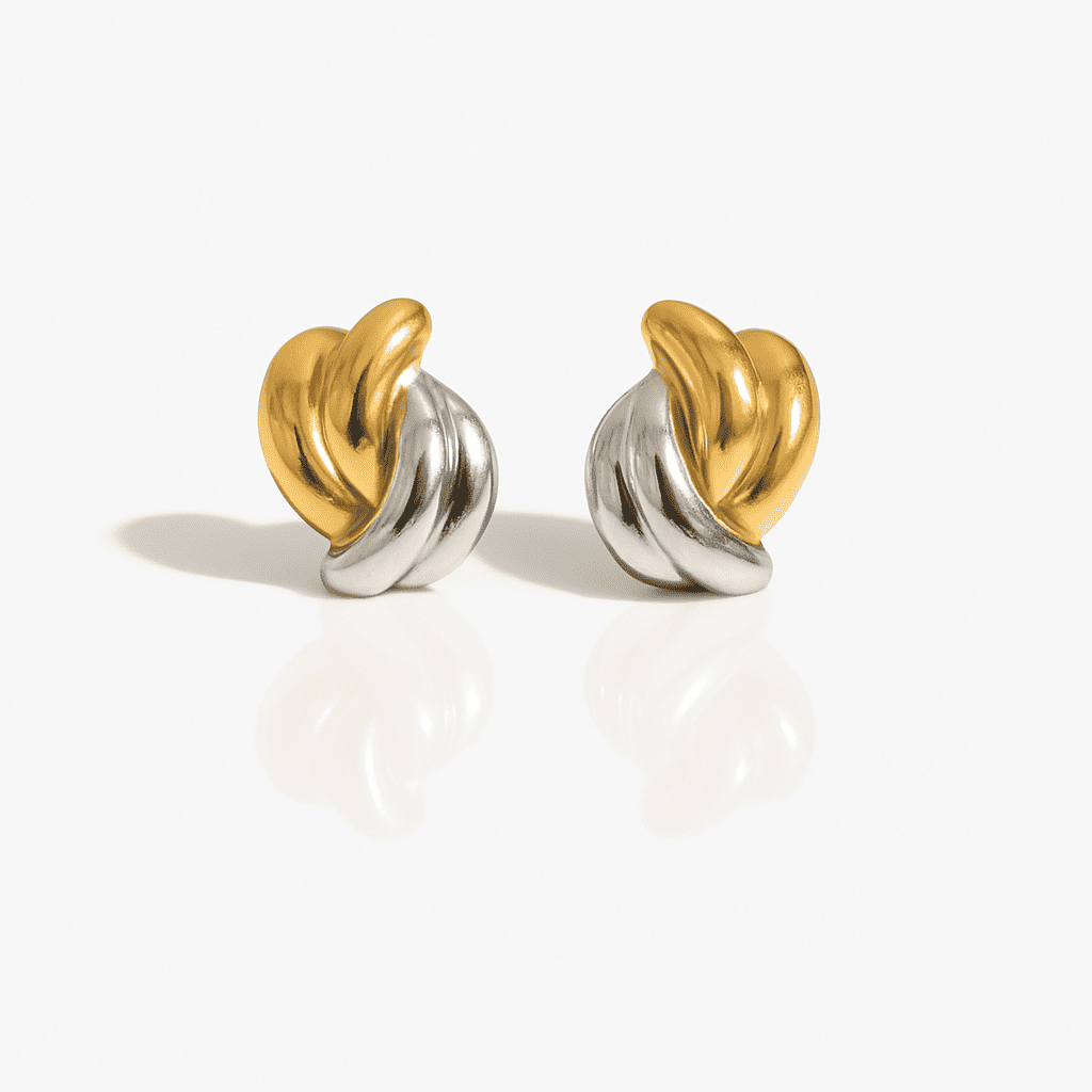 Two-tone gold and silver twist stud earrings with a sculptural modern design, elegant metallic jewelry on a white background.