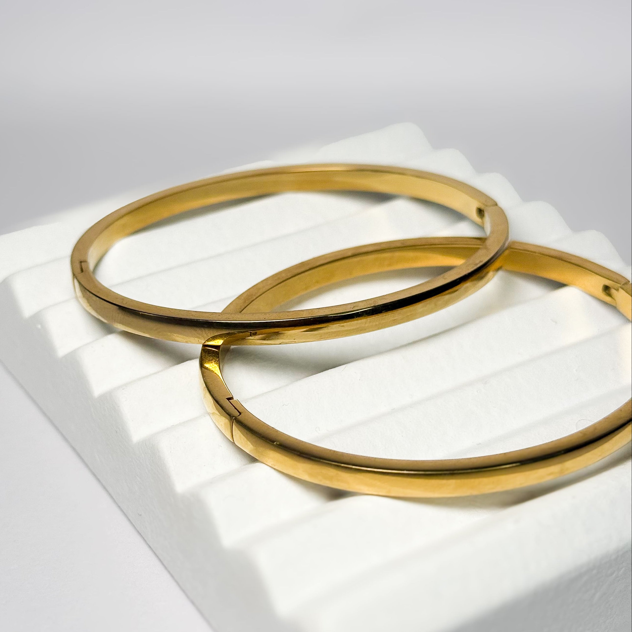 Polished gold bangle with a minimalist smooth finish