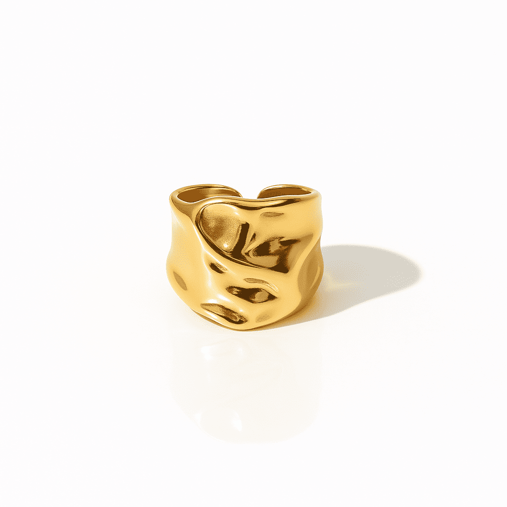 Gold statement ring with an organic wave design and polished irregular surface on a white background.