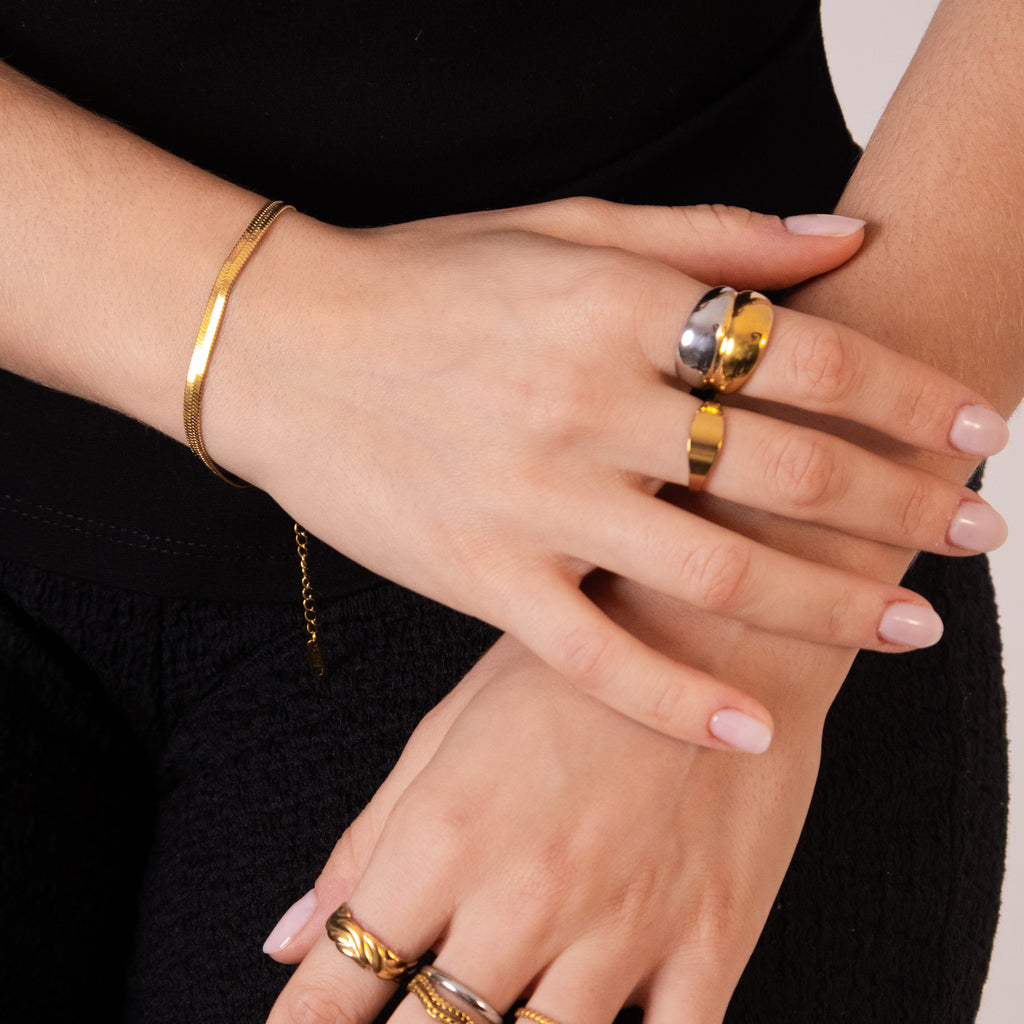 Herringbone gold bracelet with a flat, reflective pattern