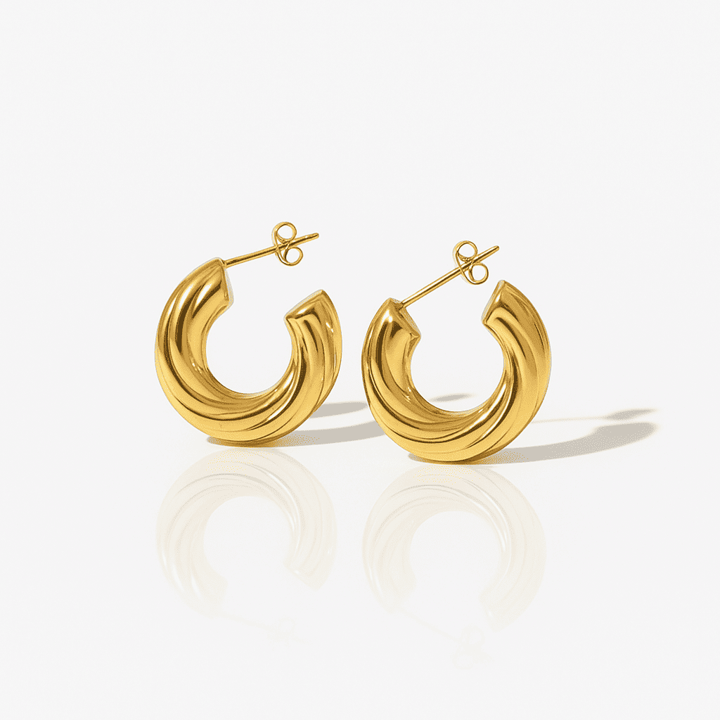 Chunky ribbed gold hoop earrings with a modern sculptural design, high-shine stainless steel jewelry on a white background.