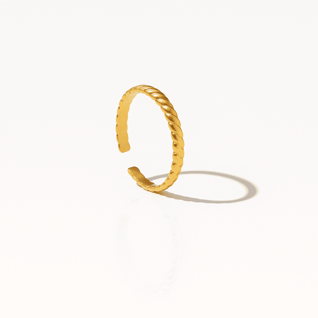 Minimalist gold ear cuff with a delicate twisted design and polished finish, photographed on a white background.